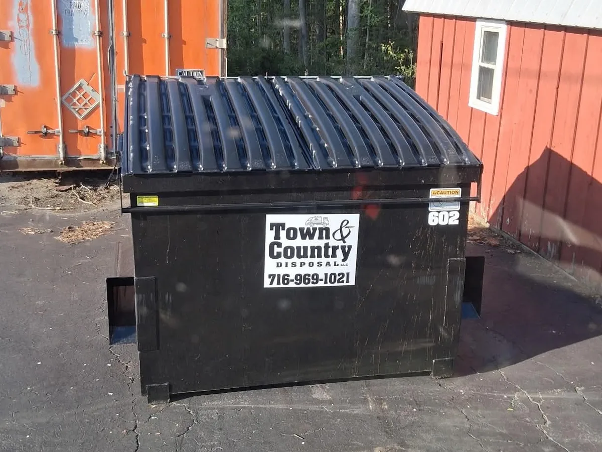 6 yard Town & Country Disposal commercial front-load dumpster behind a Western New York business